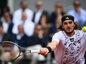 Greece's Stefanos Tsitsipas returns to Denmark's Holger Rune during their men's singles match on day nine of the Roland-Garros Open tennis tournament at the Court Philippe-Chatrier in Paris on May 30, 2022. (Photo by Christophe ARCHAMBAULT / AFP)