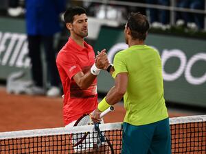 Spain's Rafael Nadal (R) shakes hands with Serbia's Novak Djokovic (L) after winning at the end of their men's singles match on day ten of the Roland-Garros Open tennis tournament at the Court Philippe-Chatrier in Paris early June 1, 2022. (Photo by Christophe ARCHAMBAULT / AFP)