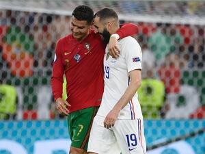 Portugal's forward Cristiano Ronaldo and France's forward Karim Benzema walk together off the pitch in half-time of the UEFA EURO 2020 Group F football match between Portugal and France at Puskas Arena in Budapest on June 23, 2021. / AFP / POOL / FRANCK FIFE