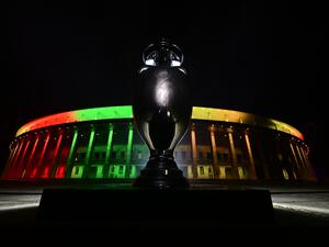 A replica of the UEFA Euro trophy is displayed in front of the Olympic stadium lit up after a presentation of the new UEFA Euro 2024 football championship logo in Berlin, on October 5, 2021. (Photo by John MACDOUGALL / AFP)