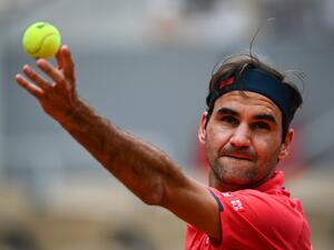 Switzerland's Roger Federer serves the ball to Croatia's Marin Cilic during their men's singles second round tennis match on Day 5 of The Roland Garros 2021 French Open tennis tournament in Paris on June 3, 2021. / AFP / Anne-Christine POUJOULAT