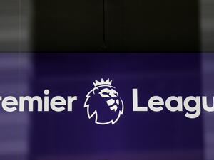 The logo is pictured through a glass window at the headquarters of the English Premier League in London on March 13, 2020. / AFP / Isabel Infantes