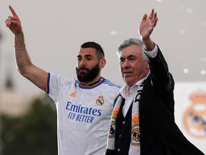 Real Madrid's French forward Karim Benzema (L) and Real Madrid's Italian coach Carlo Ancelotti wave to supporters on the Plaza Cibeles square in Madrid, after Real Madrid CF won the Spanish League football match against RCD Espanyol on April 30, 2022. (Photo by OSCAR DEL POZO / AFP)