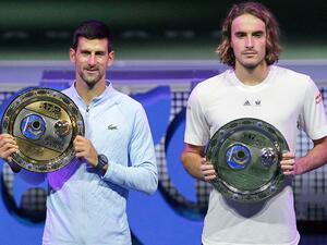 Serbia's Novak Djokovic (L) poses with his trophy after defeating Greece's Stefanos Tsitsipas (R) in their men's singles final match at the Astana Open tennis tournament in Astana on October 9, 2022. (Photo by AFP)