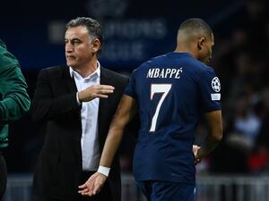 Paris Saint-Germain's French forward Kylian Mbappe (R) leaves the pitch after he is substituted by Paris Saint-Germain's French head coach Christophe Galtier (L) during the UEFA Champions League group H football match between Paris Saint-Germain (PSG) and SL Benfica, at The Parc des Princes Stadium, on October 11, 2022. (Photo by FRANCK FIFE / AFP)