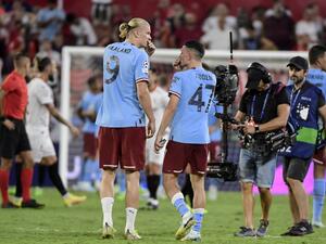 Manchester City's Norwegian striker Erling Haaland (L) speaks with Manchester City's English midfielder Phil Foden at the end of the UEFA Champions League Group G first-leg football match between Sevilla FC and Manchester City, at the Ramon Sanchez Pizjuan stadium in Seville on September 6, 2022. (Photo by CRISTINA QUICLER / AFP)