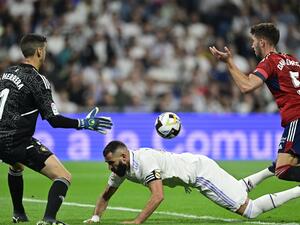 Osasuna's Spanish defender David Garcia (R) reacts after fouling Real Madrid's French forward Karim Benzema (C) during the Spanish League football match between Real Madrid CF and CA Osasuna at the Santiago Bernabeu stadium in Madrid on October 2, 2022. (Photo by JAVIER SORIANO / AFP)