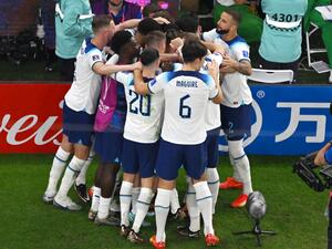 England's players celebrate after England's forward #11 Marcus Rashford scored their team's first goal during the Qatar 2022 World Cup Group B football match between Wales and England at the Ahmad Bin Ali Stadium in Al-Rayyan, west of Doha on November 29, 2022. (Photo by Antonin THUILLIER / AFP)
