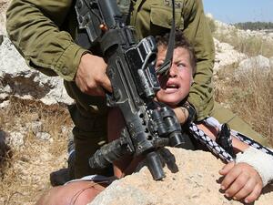 Israeli soldier grabs a Palestinian kid 