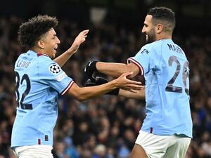 Manchester City's English defender Rico Lewis (L) celebrates scoring his team's first goal with Manchester City's Algerian midfielder Riyad Mahrez (R) during the UEFA Champions League group G football match between Manchester City and Sevilla at the Etihad Stadium in Manchester, north west England on November 2, 2022. (Photo by Oli SCARFF / AFP)