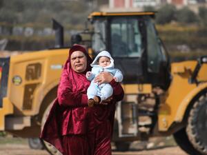 فلسطينية تحمل كفلا بعد ان هدمت قوات الاحتلال منزلها