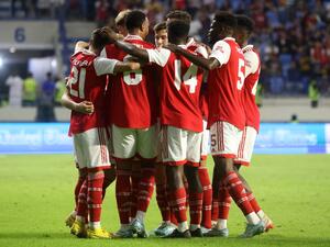 Arsenal's players gather in a huddle as they celebrate scoring during the AC Milan and Arsenal friendly match at the Dubai Super Cup 2022, at the al-Maktoum stadium in the Gulf emirate, on December 13, 2022. (Photo by KARIM SAHIB / AFP)