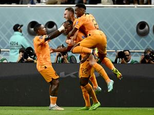 Netherlands' defender #22 Denzel Dumfries (C) celebrates with teammates after scoring his team's third goal during the Qatar 2022 World Cup round of 16 football match between the Netherlands and USA at Khalifa International Stadium in Doha on December 3, 2022. (Photo by Jewel SAMAD / AFP)