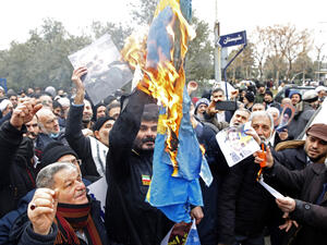 Iranians burn a Swedish flag during a protest