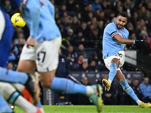 Manchester City's Algerian midfielder Riyad Mahrez scores the opening goal from this freekick during the English FA Cup third round football match between Manchester City and Chelsea at the Etihad Stadium in Manchester, north-west England, on January 8, 2023. (Photo by Oli SCARFF / AFP)