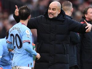 Manchester City's Spanish manager Pep Guardiola (C) reacts as he talks with Manchester City's Portuguese midfielder Bernardo Silva (L) during the English Premier League football match between Manchester United and Manchester City at Old Trafford in Manchester, north west England, on January 14, 2023. (Photo by Oli SCARFF / AFP)