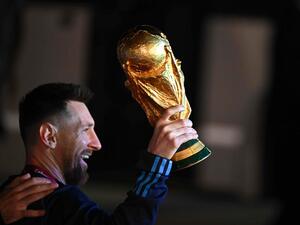 Argentina's captain and forward Lionel Messi holds the FIFA World Cup Trophy upon arrival at Ezeiza International Airport after winning the Qatar 2022 World Cup tournament in Ezeiza, Buenos Aires province, Argentina on December 20, 2022. (Photo by Luis ROBAYO / AFP)