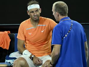 Spain's Rafael Nadal gets medical attention during the break in the men's singles match against Mackenzie McDonald of the US on day three of the Australian Open tennis tournament in Melbourne on January 18, 2023. (Photo by MANAN VATSYAYANA / AFP) 