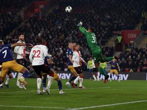 Southampton's Irish goalkeeper Gavin Bazunu (R) jumps to punch the ball away whilst making a save during the English League Cup semi-final first-leg football match between Southampton and Newcastle United at St Mary's Stadium in Southampton, southern England on January 24, 2023. (Photo by ADRIAN DENNIS / AFP)