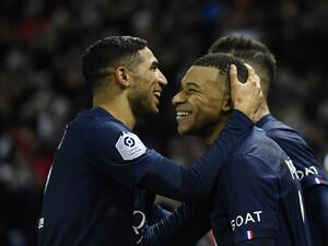 Paris Saint-Germain's French forward Kylian Mbappe (C) celebrates after scoring a penalty with Paris Saint-Germain's Moroccan defender Achraf Hakimi (L) during the French L1 football match between Paris Saint-Germain FC and RC Strasbourg Alsace at The Parc des Princes stadium in Paris on December 28, 2022. (Photo by JULIEN DE ROSA / AFP)