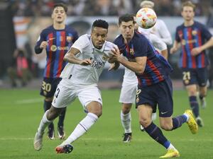 Real Madrid's Brazilian defender Eder Militao (L) fights for the ball with Barcelona's Polish forward Robert Lewandowski during the Spanish Super Cup final football match between Real Madrid CF and FC Barcelona at the King Fahd International Stadium in Riyadh, Saudi Arabia, on January 15, 2023. (Photo by Giuseppe CACACE / AFP)