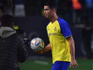 Al-Nassr's new Portuguese forward Cristiano Ronaldo carries a ball he autographed, to give the fans, during his unveiling at the Mrsool Park Stadium in the Saudi capital Riyadh on January 3, 2023. (Photo by AFP)