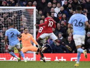 Manchester United's English striker Marcus Rashford (R) watches as Manchester United's Portuguese midfielder Bruno Fernandes (C) scores the equalising goal past Manchester City's Brazilian goalkeeper Ederson during the English Premier League football match between Manchester United and Manchester City at Old Trafford in Manchester, north west England, on January 14, 2023. (Photo by Oli SCARFF / AFP)