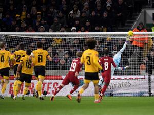 Liverpool's English midfielder Harvey Elliott (C) scores his team first goal past Wolverhampton Wanderers' Portuguese goalkeeper Jose Sa during the FA Cup third round football match between Wolverhampton Wanderers and Liverpool FC at the Molineux stadium in Wolverhampton, central England on January 17, 2023. (Photo by Oli SCARFF / AFP) 