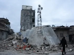 مواطن يسير على طول مبنى منهار إثر زلزال ضرب بلدة جندريس بريف مدينة عفرين شمال غرب سوريا