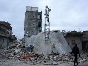 مواطن يسير على طول مبنى منهار إثر زلزال ضرب بلدة جندريس بريف مدينة عفرين شمال غرب سوريا