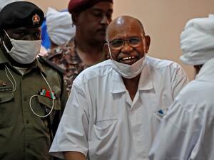 الرئيس السوداني المخلوع عمر البشير يبتسم خلال محاكمته في الخرطوم 