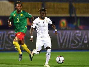 Ghana's midfielder Christian Atsu (R) is marked by Cameroon's defender Gaetan Bong during the 2019 Africa Cup of Nations (CAN) Group F football match between Cameroon and Ghana at the Ismailia Stadium on June 29, 2019. / AFP / OZAN KOSE