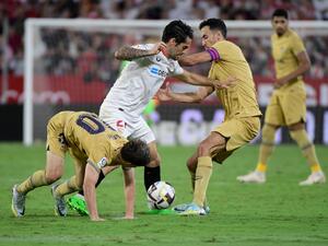 Sevilla's Spanish midfielder Isco (C) fights for the ball with Barcelona's Spanish midfielder Gavi (L) and Barcelona's Spanish midfielder Sergio Busquets during the Spanish league football match between Sevilla FC and FC Barcelona at the Ramon Sanchez Pizjuan stadium in Seville, on September 2, 2022. (Photo by CRISTINA QUICLER / AFP)