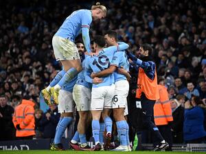 Manchester City's Norwegian striker Erling Haaland (L) jumps on teammates as they celebrate their opening goal by Manchester City's Dutch defender Nathan Ake during the English FA Cup fourth round football match between Manchester City and Arsenal at the Etihad Stadium in Manchester, northwest England, on January 27, 2023. (Photo by Oli SCARFF / AFP)