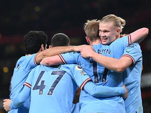 Manchester City's Norwegian striker Erling Haaland (R) celebrates with teammates after scoring his team third goal during the English Premier League football match between Arsenal and Manchester City at the Emirates Stadium in London on February 15, 2023. (Photo by Glyn KIRK / AFP)