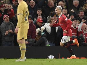 Manchester United's Brazilian midfielder Antony (R) celebrates after scoring his team second goal during the UEFA Europa league knockout round play-off second leg football match between Manchester United and FC Barcelona at Old Trafford stadium in Manchester, north west England, on February 23, 2023. (Photo by Oli SCARFF / AFP)