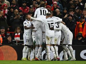 Real Madrid's French forward Karim Benzema is mobbed by teammates after scoring the team's fourth goal during the UEFA Champions League last 16 first leg football match between Liverpool and Real Madrid at Anfield in Liverpool, north west England on February 21, 2023. (Photo by Paul ELLIS / AFP) 