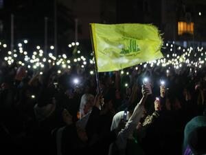 أنصار حزب الله يحملون هواتفهم ويلوحون بعلم الحزب