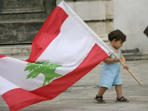 طفل صغير يحمل علم لبنان