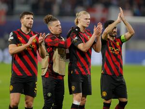 (L-R) Manchester City's Portuguese defender Ruben Dias, Manchester City's English midfielder Kalvin Phillips, Manchester City's Norwegian striker Erling Haaland and Manchester City's German midfielder Ilkay Gundogan applaud the fans after the UEFA Champions League round of 16, first-leg football match between RB Leipzig and Manchester City in Leipzig, eastern Germany on February 22, 2023. (Photo by Odd ANDERSEN / AFP)