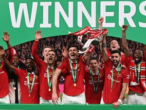 Manchester United's Portuguese midfielder Bruno Fernandes (3R) and Manchester United's English defender Harry Maguire (C) celebrate with the trophy after their victory in the English League Cup final football match between Manchester United and Newcastle United at Wembley Stadium, north-west London on February 26, 2023. Manchester United clinched their first major trophy for six years with a ruthless 2-0 win against Newcastle in the League Cup final at Wembley on Sunday. (Photo by Glyn KIRK / AFP) 