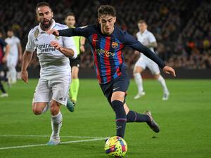 Real Madrid's Spanish defender Dani Carvajal (L) fights for the ball with Barcelona's Spanish midfielder Gavi during the Spanish league football match between FC Barcelona and Real Madrid CF at the Camp Nou stadium in Barcelona on March 19, 2023. (Photo by LLUIS GENE / AFP)
