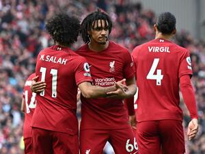 Liverpool's Egyptian striker Mohamed Salah (L) celebrates with Liverpool's English defender Trent Alexander-Arnold (C) after scoring their third goal during the English Premier League football match between Liverpool and Nottingham Forest at Anfield in Liverpool, north west England on April 22, 2023. (Photo by Paul ELLIS / AFP)