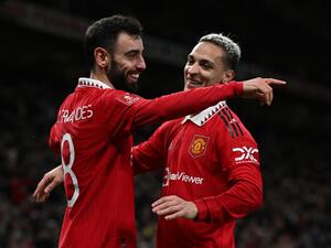 Manchester United's Portuguese midfielder Bruno Fernandes (L) celebrates with Manchester United's Brazilian midfielder Antony (R) after scoring their third goal during the English FA Cup quarter-final football match between Manchester United and Fulham at Old Trafford in Manchester, north-west England, on March 19, 2023. Man Utd won the game 3-1. (Photo by Paul ELLIS / AFP)