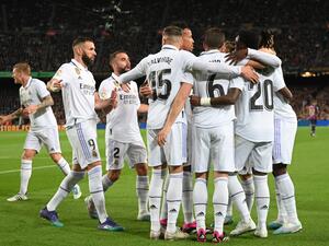 Real Madrid's players celebrate after Barcelona's Uruguayan defender Ronald Araujo scored an own goal during the Spanish league football match between FC Barcelona and Real Madrid CF at the Camp Nou stadium in Barcelona on March 19, 2023. (Photo by LLUIS GENE / AFP)