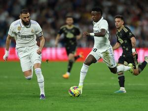Real Madrid's Brazilian forward Vinicius Junior and Real Madrid's French forward Karim Benzema (L) control the ball during the Spanish league football match between Real Madrid CF and RC Celta de Vigo at the Santiago Bernabeu stadium in Madrid on April 22, 2023. (Photo by Thomas COEX / AFP)