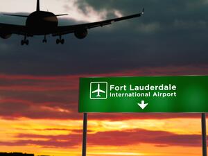 Airplane flying over sign for Fort Lauderdale-Hollywood International Airport