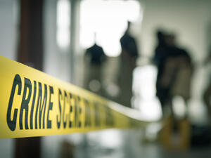crime scene tape with blurred forensic law enforcement background in cinematic tone and copy space