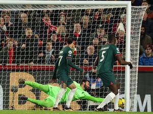 Liverpool's Brazilian goalkeeper Alisson Becker dives but is unable to prevent the ball crossing the line after a deflection off Liverpool's French defender Ibrahima Konate (R) for an own goal, during the English Premier League football match between Brentford and Liverpool at Gtech Community Stadium in London on January 2, 2023. (Photo by Adrian DENNIS / AFP)