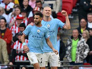 Manchester City's Algerian midfielder Riyad Mahrez (L) celebrates scoring the opening goal with Manchester City's Norwegian striker Erling Haaland during the English FA Cup semi-final football match between Manchester City and Sheffield United at Wembley Stadium in north west London on April 22, 2023. (Photo by Glyn KIRK / AFP)